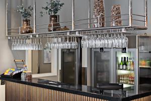 - un bar avec des verres à vin suspendus à une étagère dans l'établissement Comfort Hotel Umeå City, à Umeå