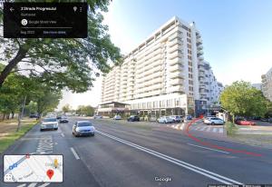 eine Straße mit Autos, die eine Straße mit einem großen Gebäude entlangfahren in der Unterkunft Central Residence Apartment 1011 in Vatra Mînăstirii Cotroceni