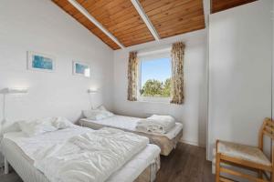 due letti in una stanza con finestra di Pool House Close To The Coast a Vestervig Altre 20 foto