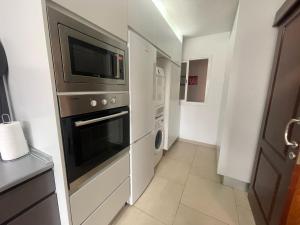 a kitchen with a microwave oven and a refrigerator at Piso Familiar Centrico Campillo in Telde