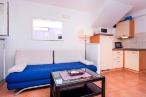 a living room with a blue couch and a table at Apartments Tomy & Domy in Dubrovnik