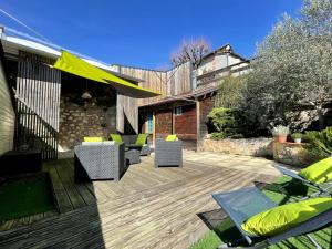 a patio with chairs and tables on a wooden deck at La Cyprienne in Saint-Cyprien