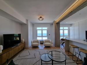 a living room with two chairs and a flat screen tv at VibesCoruña-Rubine 20 in A Coruña