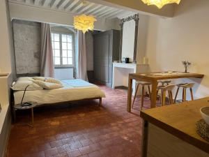 a bedroom with a bed and a kitchen with a table at La Maison de Margaret in Cluny