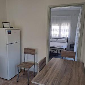 a kitchen with a table and chairs and a refrigerator at Makri square apartment in Makri