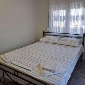 a bed with two towels on it with a window at Makri square apartment in Makri
