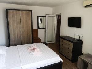 una camera da letto con un letto, una cassettiera e una televisione di Studio Sat Vacanta Free parking a Constanţa Altre 2 foto