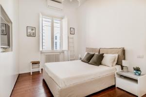 a white bedroom with a bed and a window at Casa Jordan 47 in Rome