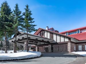 a large building with snow on the ground at Hakuba Tokyu Hotel in Hakuba