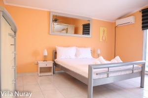 a bedroom with a bed and a mirror on the wall at Villa Nuray in Keramoti