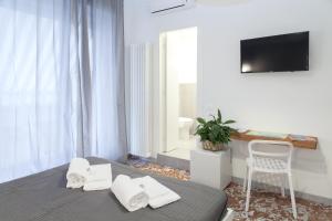 a bedroom with a bed and a chair and a television at La Casa delle Acciughe Guest House in La Spezia