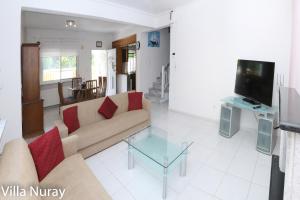a living room with a couch and a tv at Villa Nuray in Keramoti