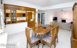 a kitchen and living room with a wooden table and chairs at Villa Nuray in Keramoti