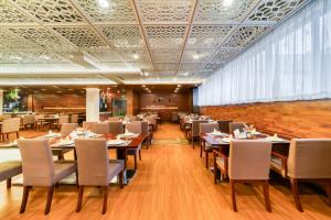 a restaurant with tables and chairs in a room at Haiwaihai Nachuan Hotel Wanda Plaza Dujiaqiao Subway Station in Hangzhou