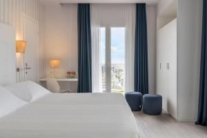 A bed or beds in a room at Hotel Fedora Riccione