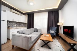 a living room with a couch and a table at Bakırk&ouml;y Zeugma Suit Otel in Istanbul