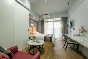 a hotel room with a bed and a table at Nuomo Times You Apartment in Guangzhou