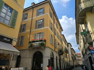 a tall yellow building with a balcony on a street at Russomanno Apartments in Como