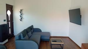 a living room with a blue couch and a tv at Marija šimičić in Rab