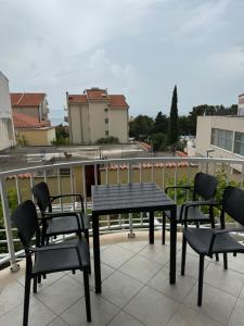 a black table and chairs on a balcony at House 100m from the beach with free parking in Baška Voda