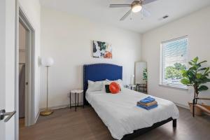 a bedroom with a bed with a blue headboard at Modern Nulu 2BR CozySuites 06 in Louisville