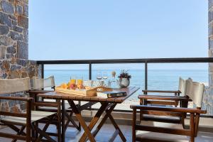a dining room with a table with a view of the ocean at Creteco Hotel & Suites in Gournes
