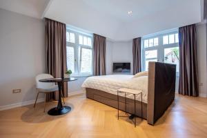 サラエボにあるEngadin Suite in Heart of Cityのベッドとテーブルと椅子のある寝室