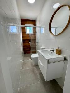 Un baño blanco con inodoro y espejo. en Apartamentos Muñoz Fornell 2, en Chiclana de la Frontera