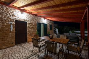 a patio with a wooden ceiling and a table and chairs at Apartment Kosljun with pool in Košljun
