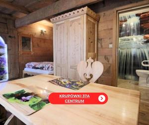 pokój ze stołem i pokój z łóżkiem w obiekcie Góralski Domek Waluś Zakopane - ŚCISŁE CENTRUM - Jedyny domek na Krupówkach w Zakopanem