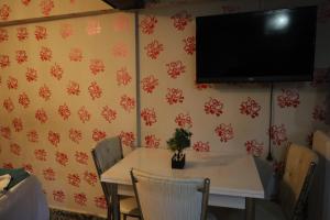 ein Esszimmer mit einem Tisch und einem TV an der Wand in der Unterkunft Galaxy Hotel Sultanahmet in Istanbul