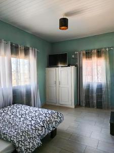a bedroom with a bed and a flat screen tv at Villa Spacieuse et Confort in Antananarivo +12 photos