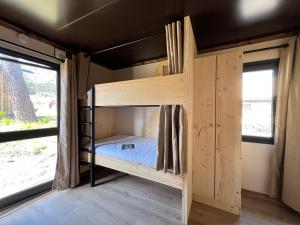 a bunk bed in a tiny house at Huttopia Lagoa de Óbidos in Casal do Narcizo