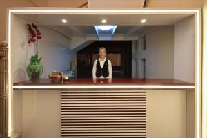 a woman standing behind a counter in a kitchen at City Park Hotel in Chişinău