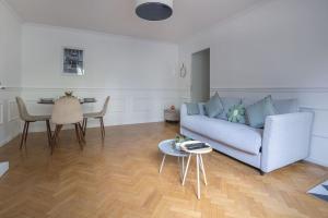 a living room with a blue couch and a table at The Smile House // Bussy-Saint-Georges in Bussy-Saint-Georges