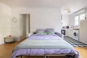 a bedroom with a large bed with a purple blanket at The Smile House // Bussy-Saint-Georges in Bussy-Saint-Georges