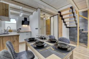a kitchen and dining room with a table and chairs at Domki Rynek16 in Tylicz