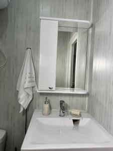 a bathroom with a white sink and a mirror at Студия in Karagandy