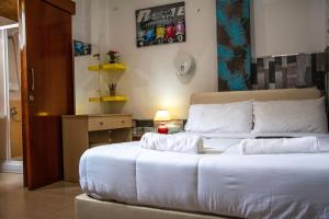 a bedroom with a bed with white sheets and a lamp at Marina's Rooms in Larnaca