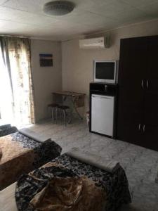 a room with two beds and a television and a table at Комплекс Дворъ in Varna City
