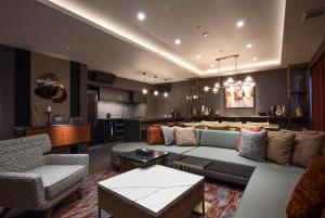 a living room with a couch and a kitchen at Spa World HOTEL&RESORT in Osaka