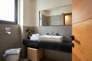 a bathroom with a sink and a mirror at Creteco Hotel & Suites in Gournes