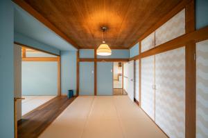 a hallway with blue walls and a wooden ceiling at 白浜レジデンス 1日1組限定 ファミリー向け 炭火焼イタリアンディナー付き in Minamiboso