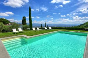 a swimming pool with lounge chairs in a yard at Villa Mami by PosarelliVillas in Serravalle Pistoiese