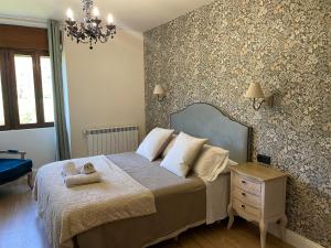 a bedroom with a bed with a dresser and a lamp at Leyendas Del Pirineo in Fiscal