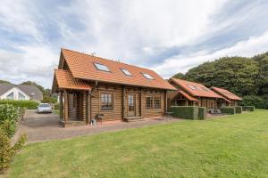 a log cabin with a car parked in a yard at Blockhausferien Rügen - Meerblick in Sassnitz