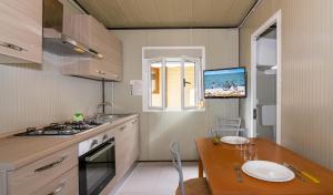 a kitchen with a table and a stove top oven at Camping Europa in Marina di Massa