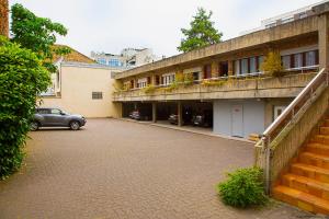 un parking avec une voiture garée devant un bâtiment dans l'établissement Best Western Select Hotel, à Boulogne-Billancourt