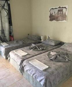 a group of three beds in a room at Комплекс Дворъ in Varna City