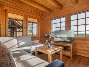 a living room with a couch and a flat screen tv at Blockhaus Vasco da Gama - Meerblick Reihe 1 und eigene Sauna in Sassnitz